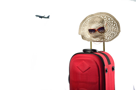 Suitcase and summer hat isolated on white backgroundの写真素材
