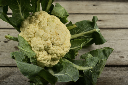 Close-up of Cauliflower with leaf on wooden background.の写真素材