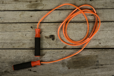 jumping rope and fruit on wooden background.