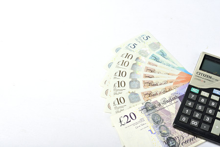 British Pound paper money and calculator isolated on white backgroundの写真素材