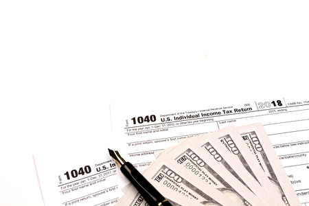 Calculating US tax with 1040 tax form on white background