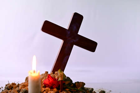Giving respect to human soul. Give a candle and rose under Jesus cross.の写真素材