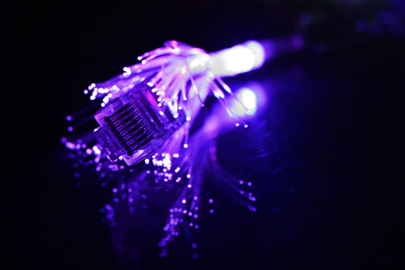 Network cable with fiber optics light on black background