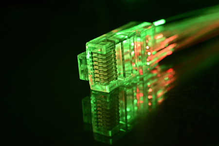 Network connection plug with fiber optics cable isolated on black backgroundの写真素材