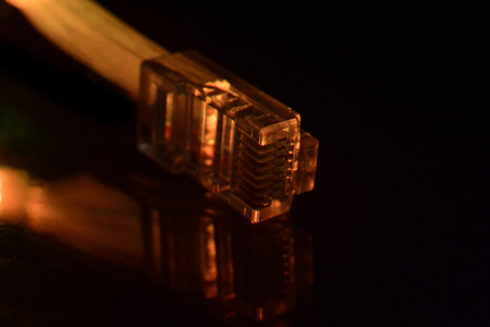 Network connection plug with fiber optics cable isolated on black background