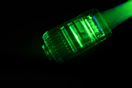 Network connection plug with fiber optics cable isolated on black backgroundの写真素材