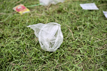 Waste Plastic packets are dumped on green grass field