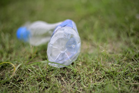 Discarded plastic water bottle on green grass field.の写真素材