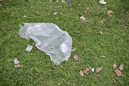 Waste Plastic packets are dumped on green grass fieldの写真素材