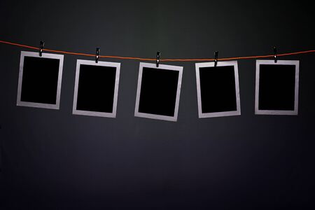 Blank photographs hanging on a rope in photography dark roomの写真素材