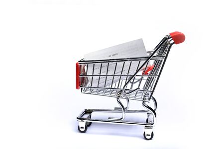 Shopping cart with receipt isolated on white background. Concept of grocery expenses and consumerism.の写真素材