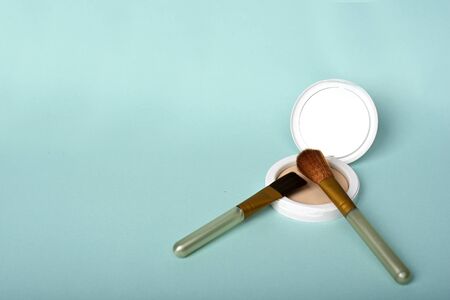 face powder with makeup brush isolated on blue background