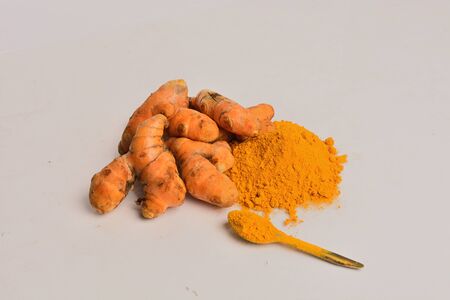 Turmeric rhizome and powder isolated on gray backgroundの写真素材