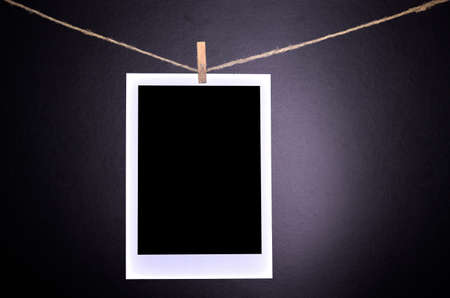 Close-up of blank  photographs hanging on a clothesline in darkroom.の写真素材