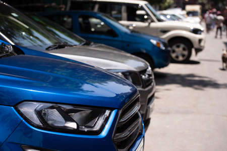Front view of the of cars parked in a row beside road in city Parking lotの写真素材