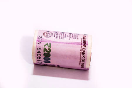 Indian two thousand rupees rolled up banknote isolated on white background.の写真素材