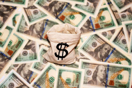 Jute sack with dollar sign on dollar paper currency banknote banknotesの写真素材