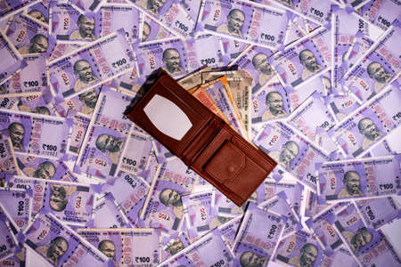 Wallets with Indian currency on Indian one hundred rupees background.の写真素材