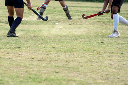 Boys are playing hockey. Hockey going to hit hockey ball.の写真素材