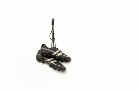 soccer spikes are hanging against white backgroundの写真素材