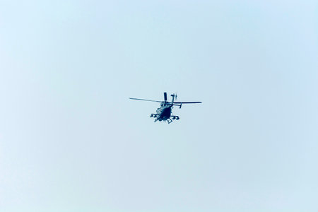 Military helicopter flying in the blue sky, closeup of photo.の写真素材