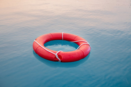 Red swim tube floating on blue water in water park for pubic security purpose.の写真素材