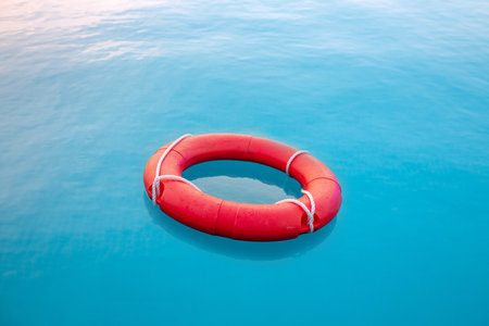 Red swim tube floating on blue water in water park for pubic security purpose.