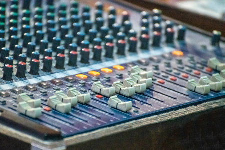 Sound engineer using mixing console to produce a sound track.の写真素材