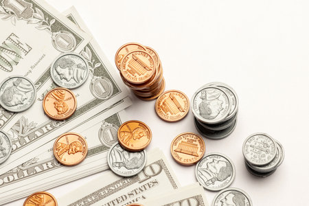 US coin and paper currency ascending like a bar graph isolated on white table