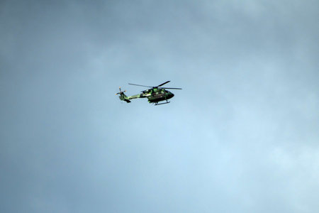 Helicopter is flying against isolated overcast dark blue skyの写真素材