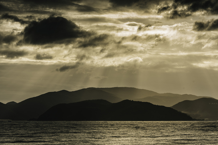 Sunlight that penetrates the clouds and spills into the seaの写真素材