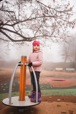 Joyful girl having fun on carousel outdoorsの写真素材