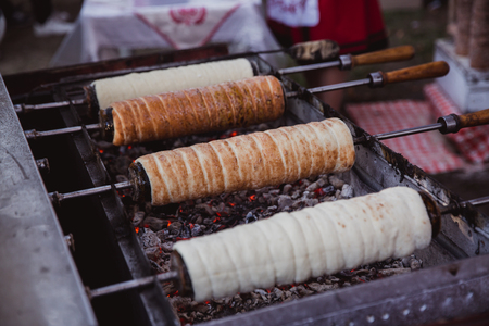 The baking of Kurtoskalacs, the traditional hungarian spit cake, in a pastry shop. Festival, Kurtoskalacs Fesztival in Budapest, Hungary.の写真素材