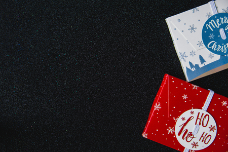 Christmas composition. Christmas gifts red and white boxes on black shine background with copy space...