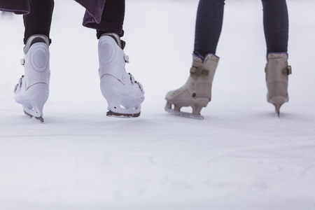 close-up of womens legs on skates in winter on an open skating rink, place for textの写真素材