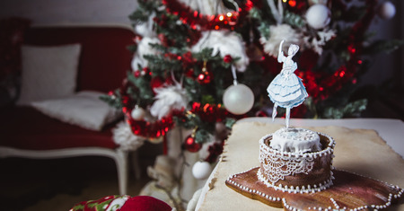 Beautiful female ballet dancer on a music box made from gingerbread with Christmas tree on...