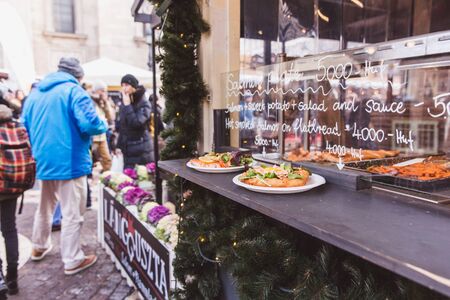 BUDAPEST, HUNGARY - DECEMBER 19, 2018: Tourists and local people enjoying the beautiful Christmas Market at St. Stephens Square in front of the St. Stephens Basilica.のeditorial素材