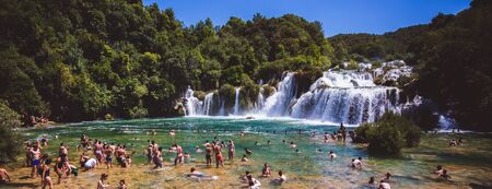KRKA NATIONAL PARK, CROATIA - AUG 13, 2015: Plenty of tourists enjoy swimin in Krka waterfalls in the Krka National Park in Croatiaのeditorial素材