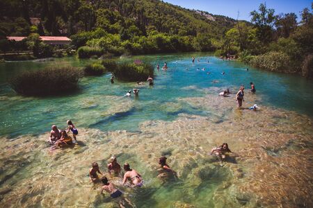 KRKA NATIONAL PARK, CROATIA - AUG 13, 2015: Plenty of tourists enjoy swimin in Krka waterfalls in the Krka National Park in Croatiaのeditorial素材