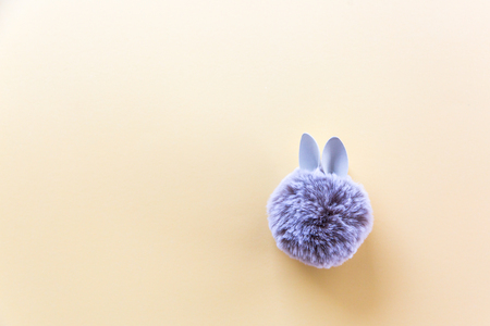 Fur ball with bunny rabbit ears on bright background. Easter minimal concept. Flat-layの写真素材
