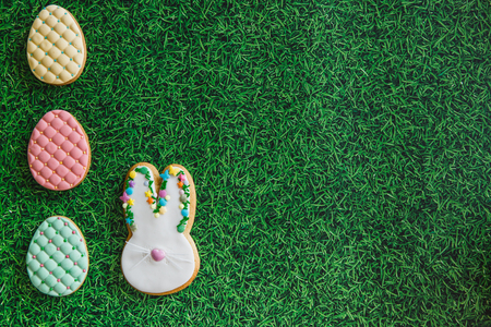 Easter composition with easter cookies eggs nad rabbit on green grass background. Easter concept with copy space. Flat lay, top viewの写真素材