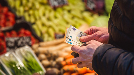 Man takes money euro banknote out from wallet on marketの写真素材
