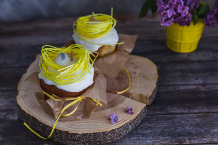Easter Cakes decorated with yellow nest and eggs, lilac on background - Traditional Kulich, Paska...