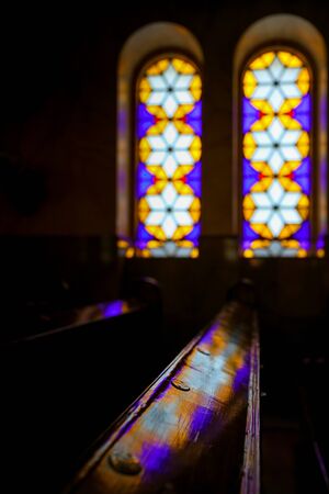 BUDAPEST, HUNGARY- March 30, 2017: Stained glass window and colored light reflection on wooden pews in the Dohany Street Synagogue in Budapestのeditorial素材