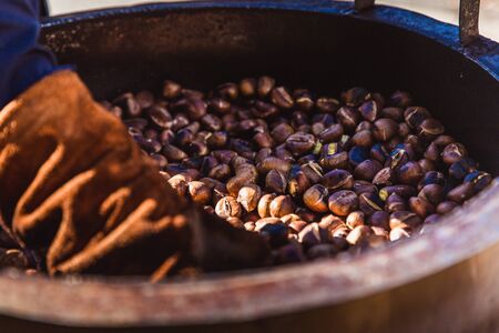 Person makes Roasted Chestnut outside in cold weatherの写真素材