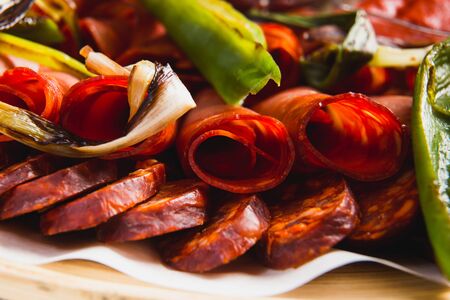Assorted meat and sausages and grilled vegetables on a round plateの写真素材