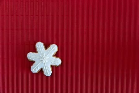 Hand painted Christmas gingerbread white snowflake on a red corrugated background. Card concept. Top...