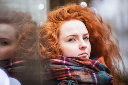 Portrait red hair girl in modern colorful scarf outside
