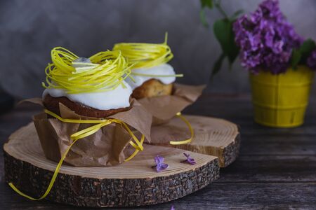 Easter Cakes decorated with yellow nest and eggs, lilac on background - Traditional Kulich, Paska...