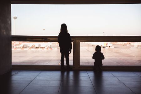 Two little girls are looking to airplans in airport waiting lounge in Budapestの写真素材